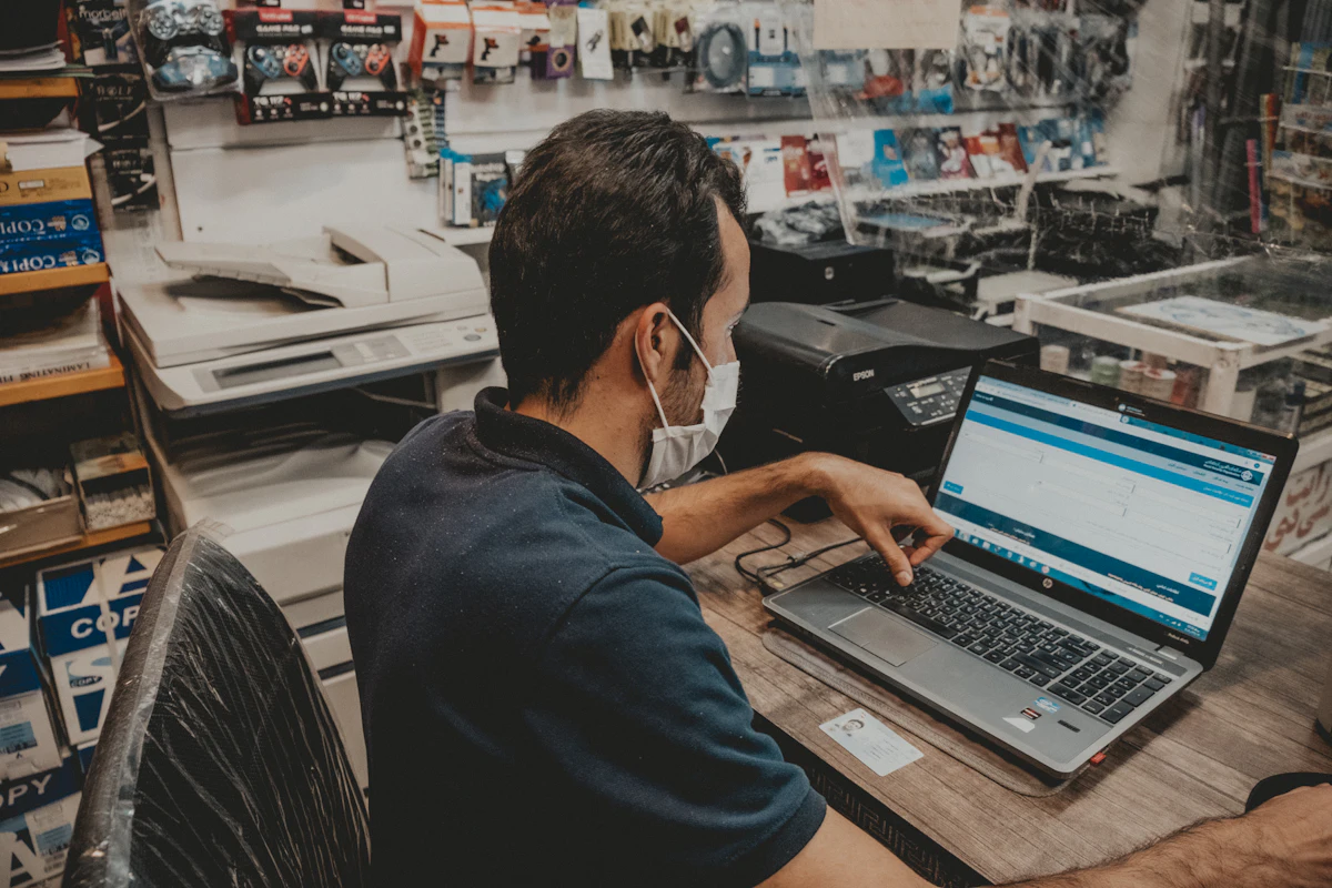Dueño de negocio pasando su lista de productos en la computadora